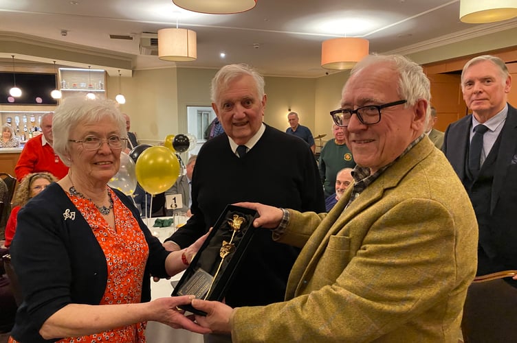 Rosemarie Lewis is presented with a golden rose by Chepstow Male Voice Choir chairman David Benson (right) and watched by her husband Clive.