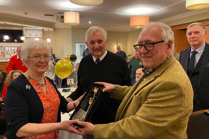 Rosemarie Lewis is presented with a golden rose by Chepstow Male Voice Choir chairman David Benson (right) and watched by her husband Clive.