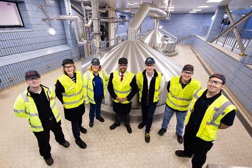 Vaughan Gething with workers at brewery