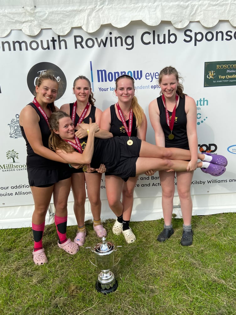 A winning crew celebrates by holding up their steerswoman.